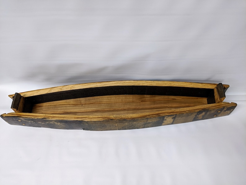 K&ouml;nnte beinhalten: Ein Holztablett aus einer wiederverwendeten Fassdauben. Das Tablett ist braun und hat eine nat&uuml;rliche Holzoptik. Es hat eine schwarze Stoffauskleidung im Inneren.