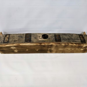 K&ouml;nnte beinhalten: Ein rustikales Holzregal aus recyceltem Holz mit Metallakzenten. Das Regal ist gebogen und hat ein Loch in der Mitte.