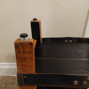 May include: Close-up of a wooden table with a black stained top and black metal accents. The table has four legs with black rubber feet.