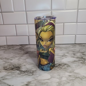 May include: A stainless steel tumbler with a colorful cartoon illustration of a woman with blonde hair wearing a blue denim skirt and a green tank top. The woman is wearing a gold chain necklace and has a purple headband in her hair.