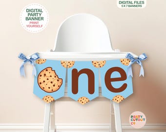 Op de afbeelding: Een blauwe en bruine printbare hoge stoelbanner met het woord "een" en chocolade chip cookie afbeeldingen. De banner is ontworpen voor een eerste verjaardagsparty.