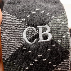May include: Gray and white patterned socks with the initials "CB" embroidered in white.