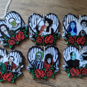 Puede incluir: Seis colgantes en forma de corazón con parejas de películas de terror populares. Cada colgante tiene un fondo blanco con manos negras, una pareja en el centro y rosas rojas en la parte inferior. Las parejas incluyen a Beetlejuice y Lydia, Jack y Sally,  el Monstruo de Frankenstein y su novia,  Freddy Krueger y Nancy,  La Novia de Chucky y Chucky, y  La Criatura de la Laguna Negra y su novia.