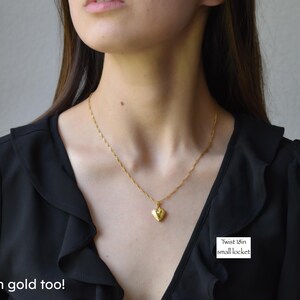 a woman wearing a necklace with a heart shaped pendant