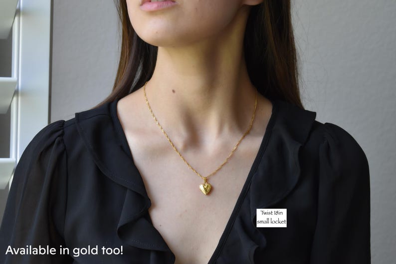 a woman wearing a necklace with a heart shaped pendant
