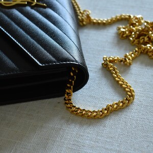 a black and gold purse sitting on top of a table