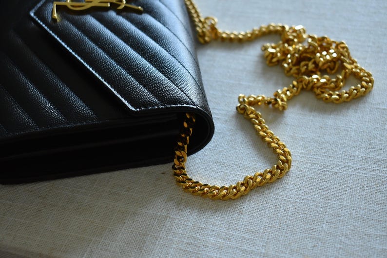 a black and gold purse sitting on top of a table