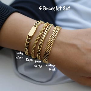A close-up of a person's wrist wearing a gold bracelet set with four different types of bracelets.