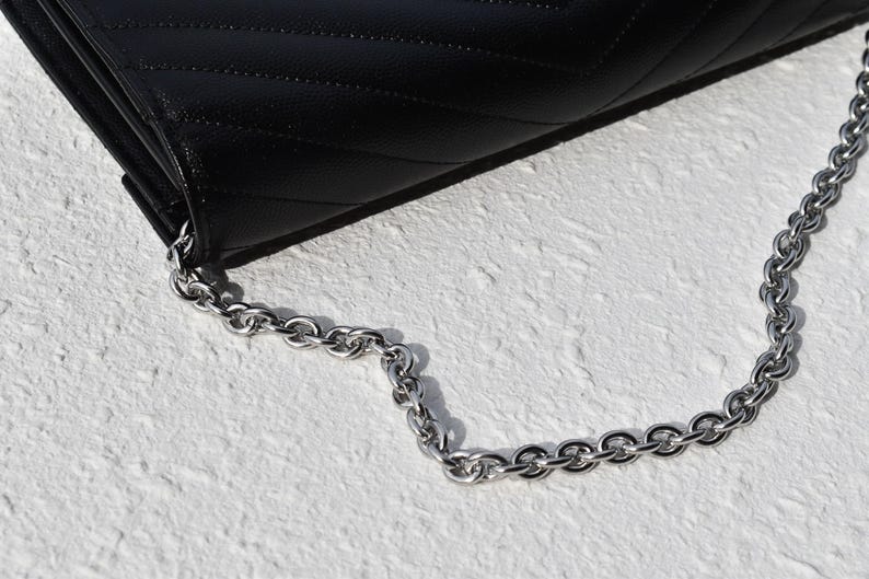 a black purse with a chain hanging from it