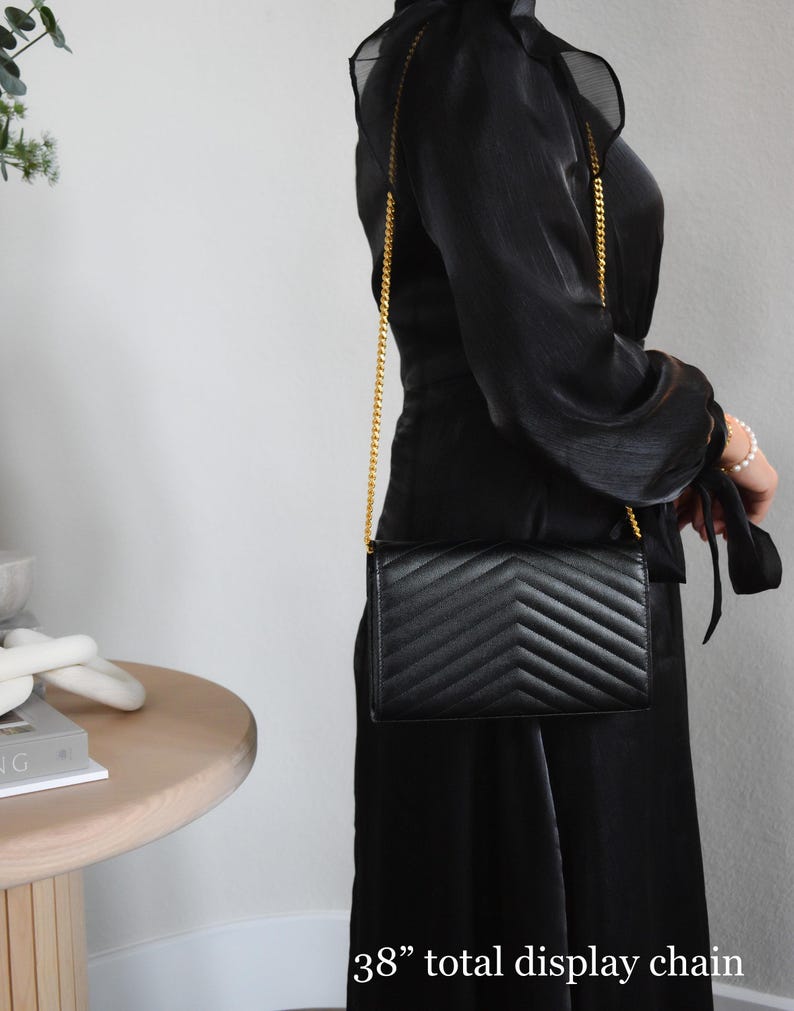 a woman in a black dress holding a black purse