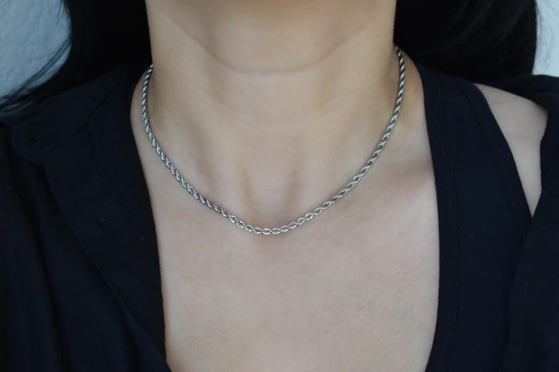 A close-up view of a person wearing a silver chain necklace.