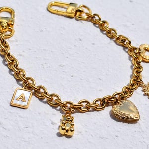 a gold bracelet with charms and charms on it