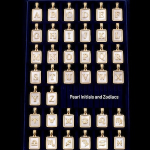 a collection of gold-colored pendants in the shape of letters of the alphabet, arranged in a grid-like pattern on a dark background.