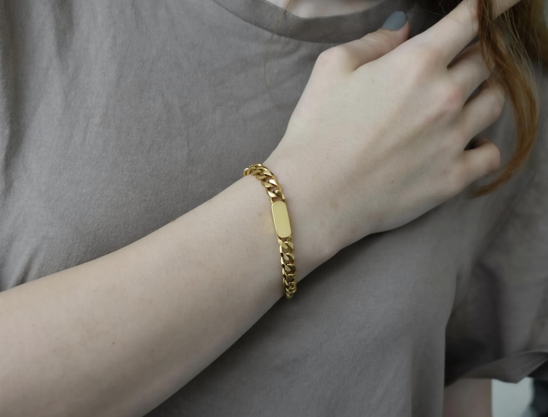 A close-up view of a person's wrist wearing a gold-colored bracelet.