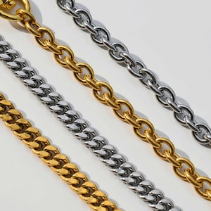 a close-up view of several metal chain necklaces with different colors and designs, including gold, silver, and bronze.
