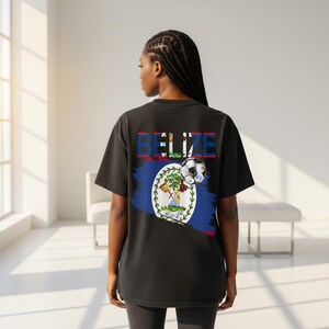 May include: Black t-shirt featuring the word "BELIZE" in colorful letters above a Belize flag design and a soccer ball. The shirt has a crew neck and short sleeves. The design is on the back of the shirt.