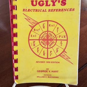 May include: A spiral-bound reference book titled Ugly's Electrical References, Revised 1999 Edition, by George V. Hart. The yellow cover features red text and a central circular diagram displaying various electrical formulas for watts, volts, and amps.