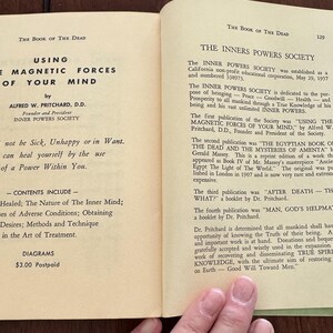 May include: Open book pages with text from "The Book of the Dead" by Alfred W. Pritchard. The left page features the title "Using the Magnetic Forces of Your Mind" and a list of contents. The right page details "The Inners Powers Society".