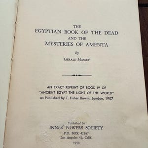 May include: Open book page with text: "THE EGYPTIAN BOOK OF THE DEAD AND THE MYSTERIES OF AMENTA" by Gerald Massey. Published by Inner Powers Society in 1958. The book is a reprint of "Ancient Egypt The Light of the World."