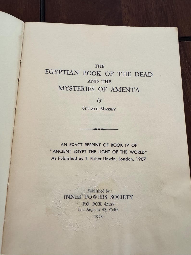May include: Open book page with text: "THE EGYPTIAN BOOK OF THE DEAD AND THE MYSTERIES OF AMENTA" by Gerald Massey. Published by Inner Powers Society in 1958. The book is a reprint of "Ancient Egypt The Light of the World."