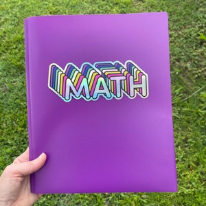 May include: Purple binder with a rainbow colored sticker that says "MATH" on it.