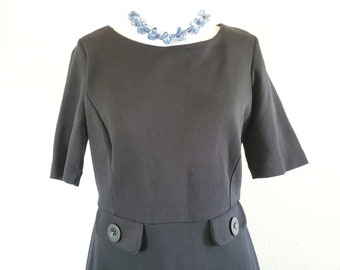 Vintage 60s 70s polyester black dress with two decorative buttons on the front and short sleeves, scoop neck