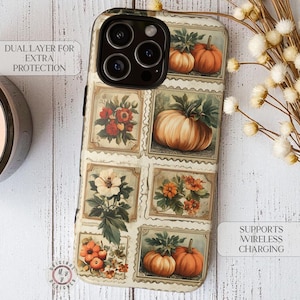 May include: A phone case featuring a vintage-style design with floral and pumpkin illustrations. The case has a cream-colored background with rectangular frames containing images of pumpkins and flowers. The case also has the text "DUAL LAYER FOR EXTRA PROTECTION" and "SUPPORTS WIRELESS CHARGING".