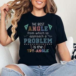 May include: Black t-shirt with a colourful graphic that says "The best angle from which to approach a problem is the try-angle".