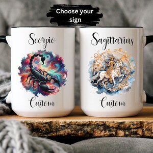May include: Two white ceramic mugs with black rims. The mug on the left features a colorful galaxy design with a black scorpion. The mug on the right features a watercolor design of a woman riding a white horse with gold accents. Both mugs have the word "Custom" printed below the design. The text "Choose your sign" is printed above the mugs.