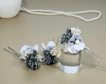 Puede incluir: Tres horquillas para el pelo florales blancas y azules con tallos de alambre plateado. Las flores están hechas de tela y tienen un aspecto delicado y vintage.