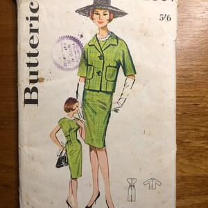 May include: Vintage Butterick sewing pattern featuring a green suit and dress design. The illustration shows a woman in a short-sleeved jacket and skirt, and a smaller image of a dress. The pattern includes bust size 31 and size 10.