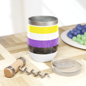 Puede incluir: Un vaso de vino de acero inoxidable con un diseño a rayas en negro, morado, blanco y amarillo. El vaso tiene una tapa con un agujero para pajita integrado y una tapa a juego.