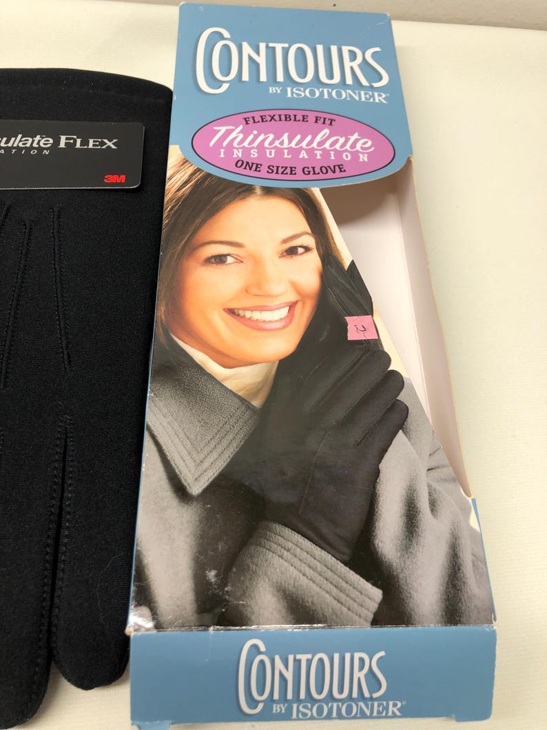 Op de afbeelding: Zwarte Thinsulate ge&iuml;soleerde handschoenen met een flexibele pasvorm, one size. De verpakking toont "Contours by Isotoner" en "Thinsulate Insulation". De handschoenen worden getoond op een vrouw met een grijze jas.