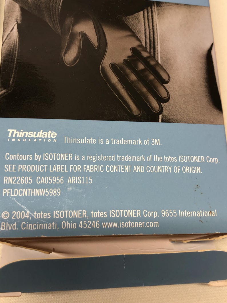 Op de afbeelding: Zwarte handschoenen met een Thinsulate isolatielabel. De handschoenen worden in close-up getoond, waarbij de vingers van de handschoen duidelijk zichtbaar zijn. Het Thinsulate-logo en merkinformatie zijn ook zichtbaar.