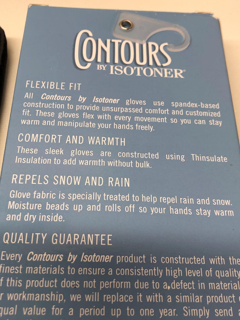 Op de afbeelding: Een blauw productlabel voor Contours by Isotoner handschoenen. Het label bevat witte tekst die de flexibele pasvorm, het comfort, de warmte en het vermogen van de handschoenen om sneeuw en regen af te stoten beschrijft. Het label bevat ook een kwaliteitsgarantie.