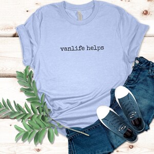 May include: A light blue t-shirt with the text "vanlife helps" printed in black on the front.