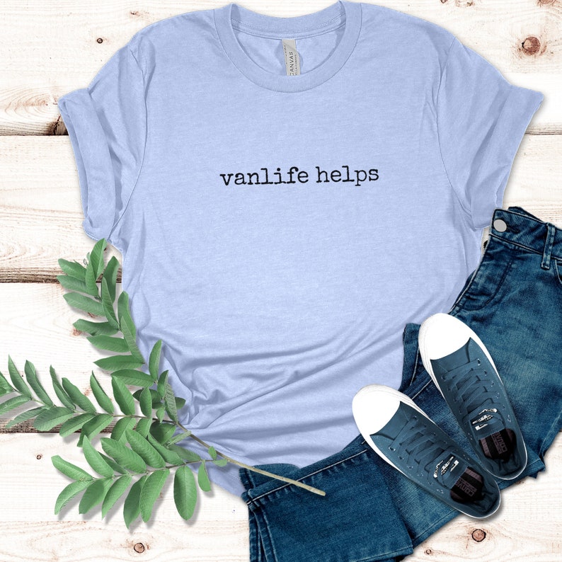 May include: A light blue t-shirt with the text "vanlife helps" printed in black on the front.