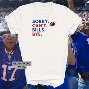 May include: White t-shirt with the text "SORRY. CAN'T. BILLS. BYE." in red, blue, and black lettering. A football icon is next to the text. The shirt is a Gildan 64000.