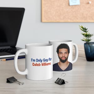 以下が含まれることがあります： 「I'm Only Gay For Caleb Williams」の文字が青と赤でプリントされた白いセラミックマグ。右側のマグには男性の肖像画が描かれています。マグは明るい色の表面に置かれています。
