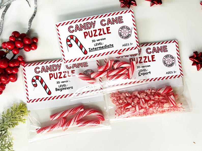 Puede incluir: Rompecabezas de bastones de caramelo en bolsas transparentes, con diferentes niveles de dificultad: Principiante, Intermedio y Experto. Cada rompecabezas est&aacute; etiquetado con "Candy Cane Puzzle". Tambi&eacute;n se ven bastones de caramelo rojos y blancos.