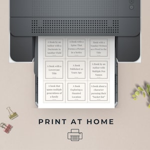 May include: Printable book bingo card with 9 squares, each containing a different book description. The card is printed on white paper and has a black and white design. The text on the card reads: "A Book by an Author with a Doctorate in Another Field", "A Book with a Spine That Forms a Picture in a Series", "Book with a Number Written as a Word in the Title", "A Book with a Lowercase Title", "A Book Published 10 Years Ago", "A Book by an Author with Multiple Pen Names", "A book that spans multiple generations of a family", "A Book Exploring a Haunted Location", "A book about a character pursuing their "bucket list". The card also includes the text "PRINT AT HOME" and a printer icon.