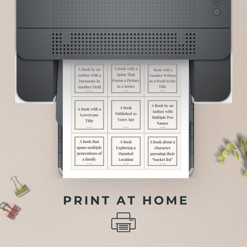 May include: Printable book bingo card with 9 squares, each containing a different book description. The card is printed on white paper and has a black and white design. The text on the card reads: "A Book by an Author with a Doctorate in Another Field", "A Book with a Spine That Forms a Picture in a Series", "Book with a Number Written as a Word in the Title", "A Book with a Lowercase Title", "A Book Published 10 Years Ago", "A Book by an Author with Multiple Pen Names", "A book that spans multiple generations of a family", "A Book Exploring a Haunted Location", "A book about a character pursuing their "bucket list". The card also includes the text "PRINT AT HOME" and a printer icon.