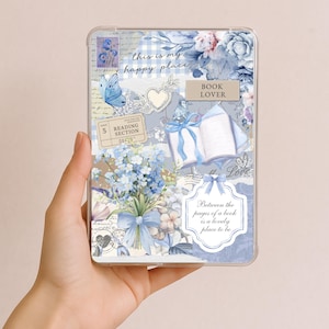 May include: A clear tablet case with a collage design featuring blue flowers, butterflies, and book-themed elements. Text includes "this is my happy place," "BOOK LOVER," and "Between the pages of a book is a lovely place to be."