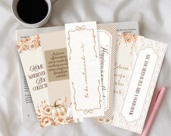 Puede incluir: Un conjunto de marcapáginas decorativos con diseños florales y otoñales. Los marcapáginas presentan citas como "Home Wherever Books Collect" y "All You Need Is Tea and a Good Book". También se ven una taza de café y un bolígrafo rosa.