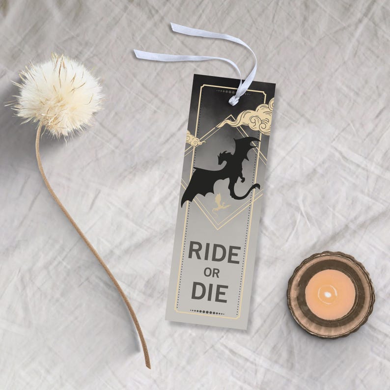 May include: A black and gold bookmark with a silhouette of a dragon and the text "Ride or Die".