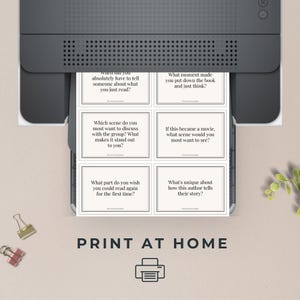 May include: A black printer printing discussion cards with questions about books. The cards are white with black text. The phrase "PRINT AT HOME" is printed below the cards.