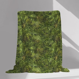 May include: A green throw blanket with a mossy pattern. The blanket is folded and displayed on a white surface.