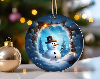 Puede incluir: Adorno navideño redondo con una escena invernal. Representa un muñeco de nieve con sombrero de copa y nariz de zanahoria. El adorno azul tiene una cuerda dorada para colgar. Una bola de Navidad dorada está en primer plano.
