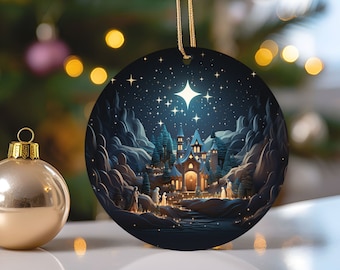 Puede incluir: Un adorno navideño redondo con un fondo azul oscuro que representa una escena de pueblo nevado con una estrella brillando intensamente en el cielo nocturno. El pueblo está iluminado con luces amarillas cálidas y hay figuras caminando hacia una iglesia.