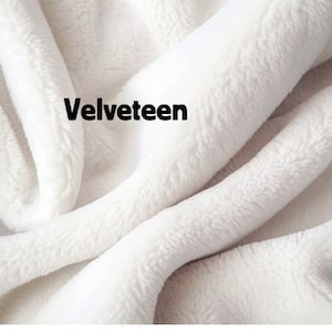 May include: Close-up of a white velvety fabric. The fabric is soft and plush, with a subtle texture.